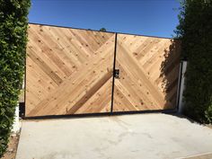 a large wooden gate in the middle of a driveway