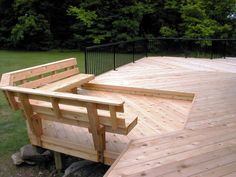 a wooden bench sitting on the back of a truck in front of some grass and trees