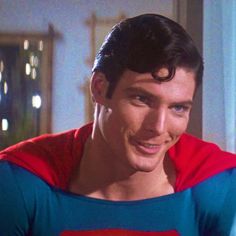 a man in a superman costume smiling at the camera