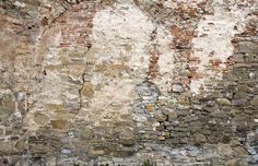 an old brick wall with peeling paint on it