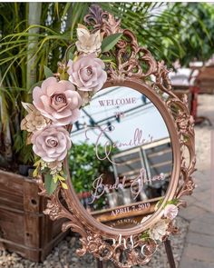 there is a mirror with flowers on it in front of some potted planters