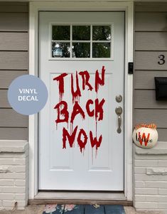 a white door with the words turn back now painted on it and an orange pumpkin