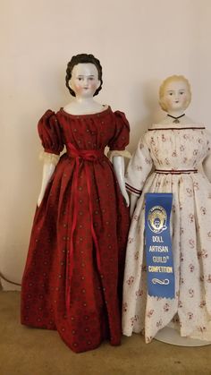 two dolls are standing next to each other