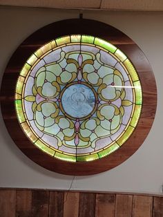 a round stained glass window on the side of a wall with wood paneling around it