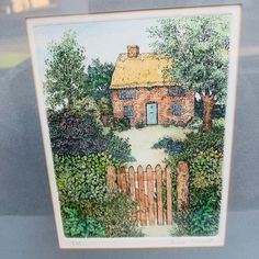 a drawing of a house with a fence and trees in the front yard is on display