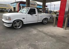 a white truck parked in front of a gas station