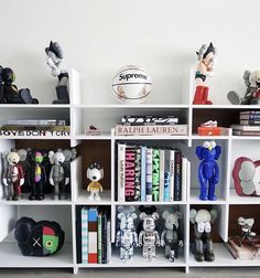 a book shelf filled with lots of books and figurines on top of it