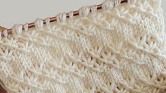 a close up view of a white knitted blanket