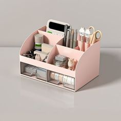 a pink desk organizer with various items in it