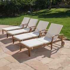 four lounge chairs sitting on top of a stone patio