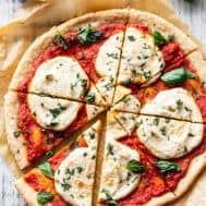 the best palen and vegan homemade pizza is cut into four slices with basil on top