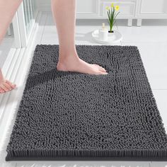 a person standing on top of a bathroom rug