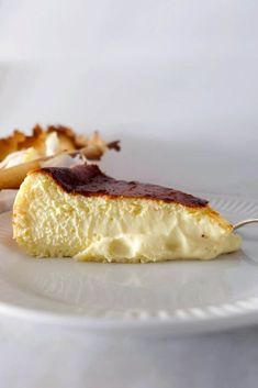 a piece of cheesecake on a plate with a fork in the foreground and another half eaten cake in the background