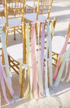 the chairs are lined up with ribbons on them