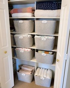 an organized closet with several baskets and blankets