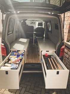 the back end of a van with two drawers open and food in it's cargo area