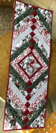 a quilted christmas table runner on top of a chair