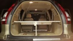 the back end of a van with its cargo door open and seats folded up in place