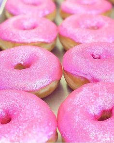 pink donuts with sprinkles are in a box