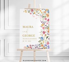 an easel with a floral wedding sign on it