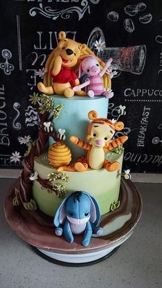 a winnie the pooh birthday cake is decorated with fondant animals and other decorations