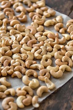 a pile of cashews sitting on top of a piece of parchment paper