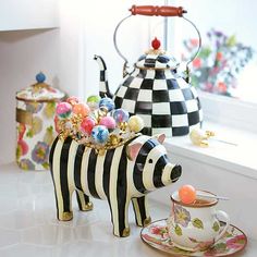 a zebra tea set sitting on top of a counter next to a cup and saucer