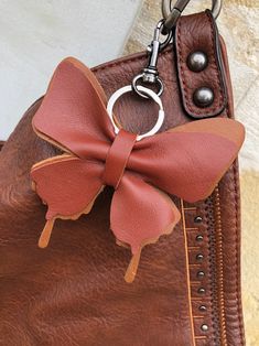 a brown purse with a red bow on it