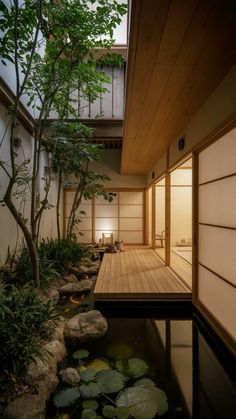 the inside of a japanese house with water and plants in front of it, as well as a wooden deck