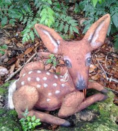 a statue of a baby deer laying on the ground