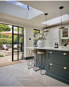 a kitchen with two stools in front of an open door that leads to the outside