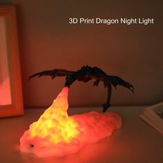 a dragon lamp sitting on top of a table next to a framed photo and a mirror