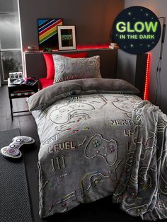 a bed with an elephant comforter on it and a neon glow in the dark sign