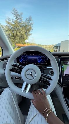 a woman driving a car with her hands on the steering wheel