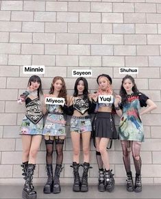 girls standing in front of a brick wall holding up signs that say mine, tokyo, seoul and myeon