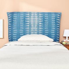 a bed with a blue headboard and white pillows