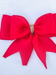 a large red bow on top of a white surface with no one in the photo