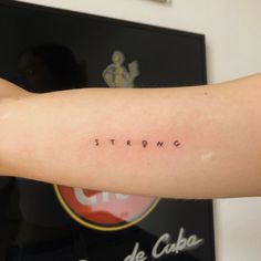 a woman's arm with the word string tattooed on her left arm, in small cursive font