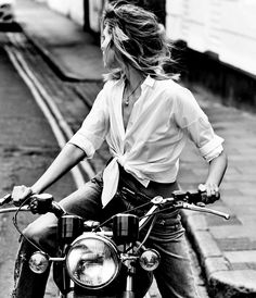 a woman riding on the back of a motorcycle