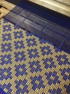 a weaving machine with yellow and blue squares on it