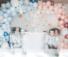 two babys are sitting in their highchairs at a table with balloons and cake