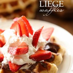 a waffle with strawberries and whipped cream on top is sitting on a plate