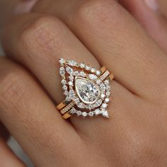 a woman's hand with an engagement ring on top of her wedding band and diamond set in the middle