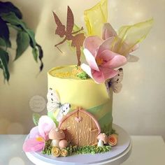 a cake decorated with flowers and fairy figurines