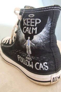 a pair of black shoes with the words keep calm and follow gas painted on them