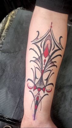 a woman's foot with a tattoo design on the side of her leg and an arrow in the middle