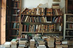 a room filled with lots of books next to a wall full of shelves covered in books