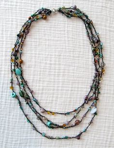 an image of a necklace with beads on the front and back of it, which is attached