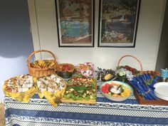 a table topped with lots of food next to two pictures on the wall behind it