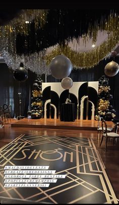 a black and white dance floor with balloons hanging from it's ceiling in front of a stage